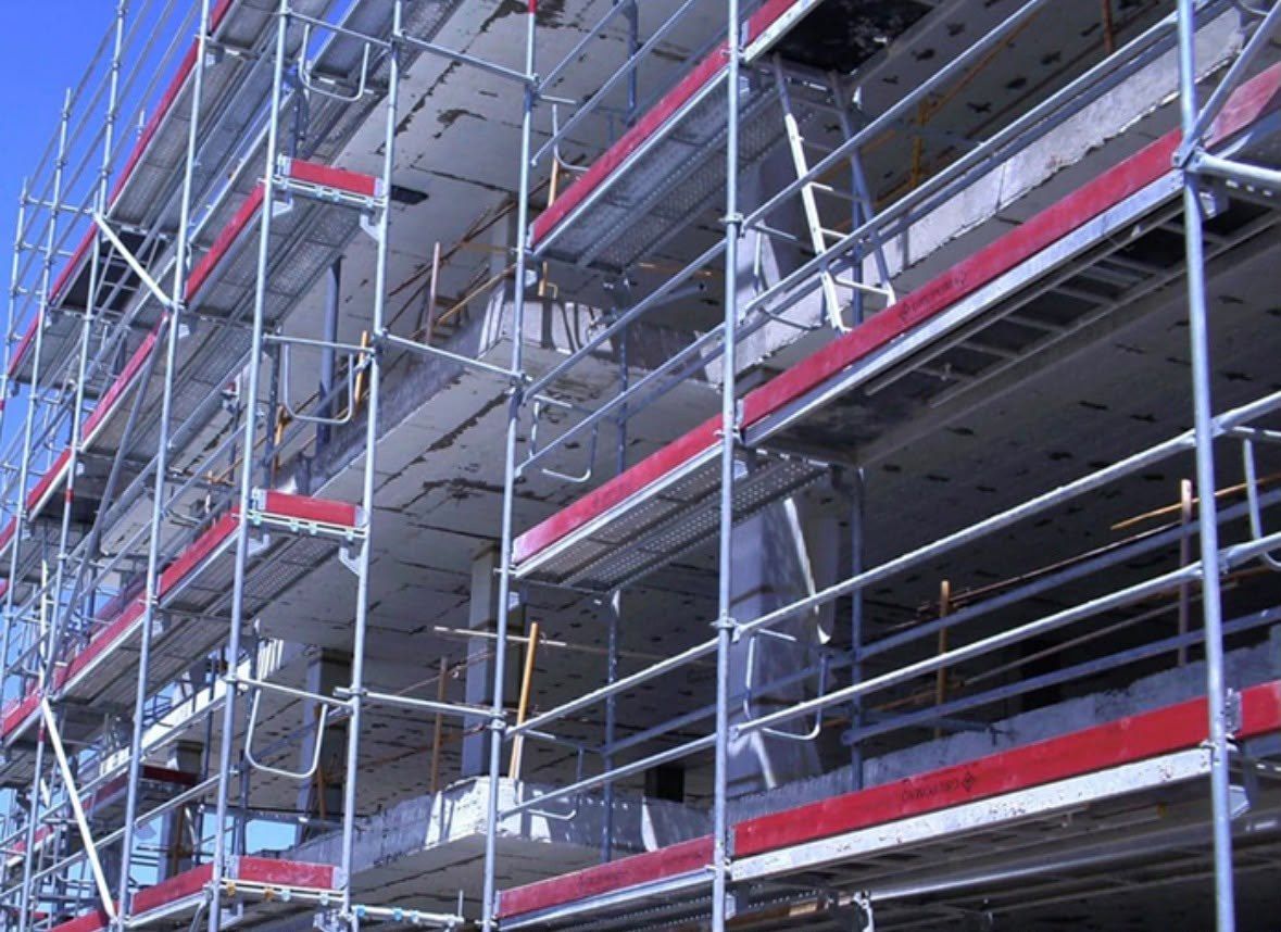 Andamio de fachada con plataformas en varios niveles sobre un edificio en construcción